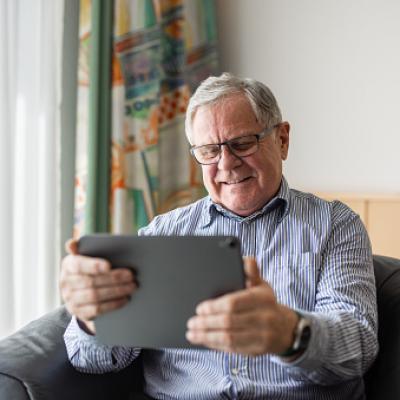 A senior man enjoying using his smart tablet