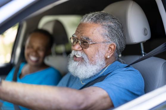 Older adult couple in a car safely driving