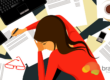 A woman sitting at a desk with papers and a laptop