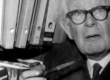 An old man with glasses smoking a cigarette