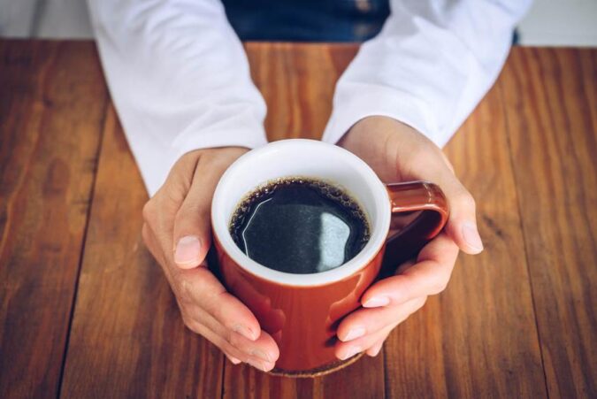 A person holding a cup of coffee in their hands