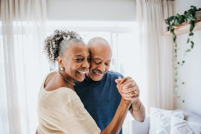 A man and woman dancing together in a bedroom