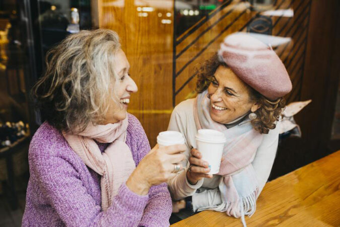 Two women sitting at a table talking to each other