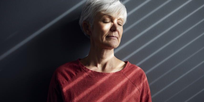 B3_Mood_1223871054_13 An older woman with white hair standing against a wall