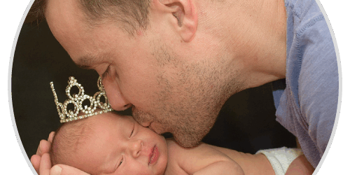 stories-michael A man kissing a baby with a crown on his head