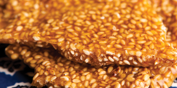canape A close up of sesame seed crackers on a blue and white cloth