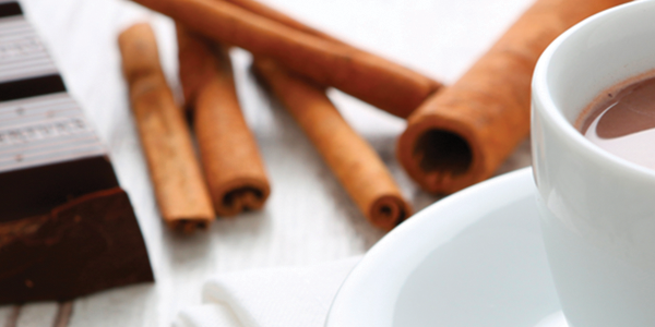 chocomex_0 A cup of hot chocolate next to some cinnamon sticks