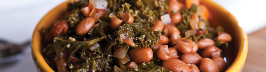 A yellow bowl filled with beans and greens