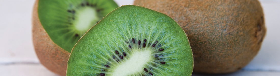 A kiwi cut in half sitting on top of a table