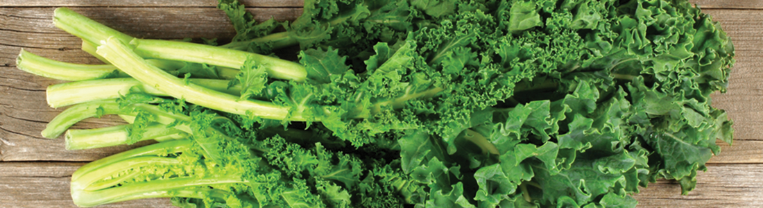 A bunch of green leafy vegetables on a wooden surface