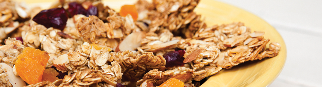 A yellow plate topped with granola and fruit