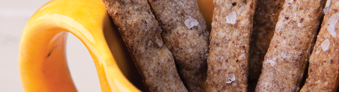 A close up of a banana and some bread sticks