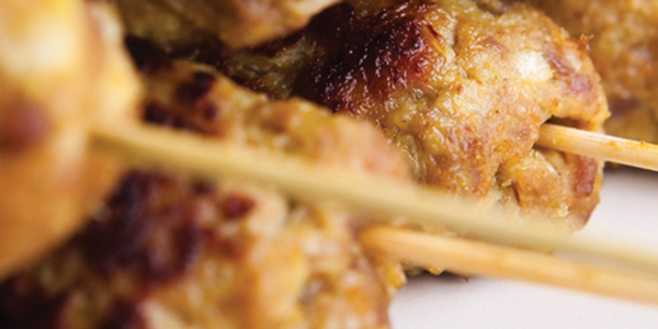 kofta Several skewers of food sitting on top of a white plate