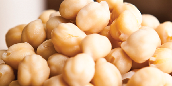 A close up of a wooden bowl filled with nuts