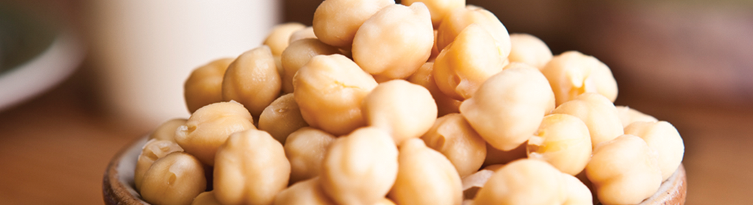 A close up of a wooden bowl filled with nuts