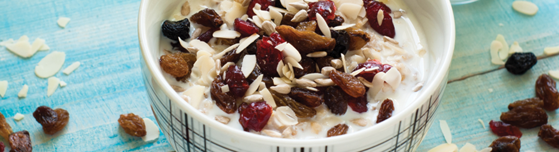 A bowl of oatmeal with raisins and nuts