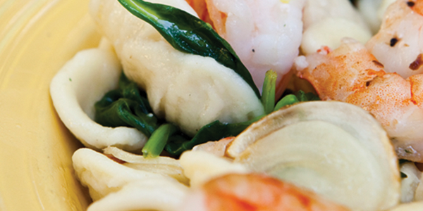 A yellow plate topped with shrimp and pasta