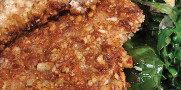 pecan A white plate topped with meat and greens