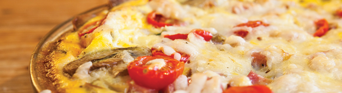 A close up of a pizza with tomatoes and cheese