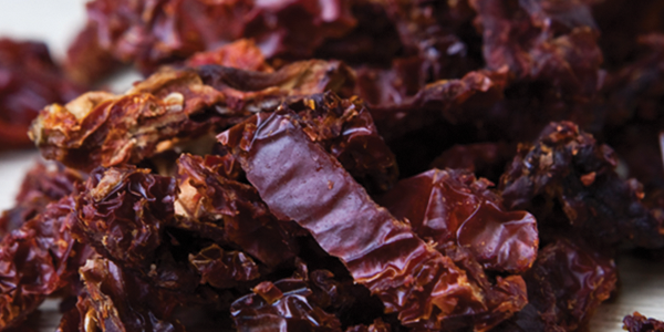 sundried A pile of dried red raisins sitting on top of a table