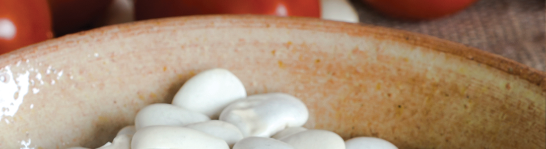 A wooden bowl filled with mushrooms on top of a table