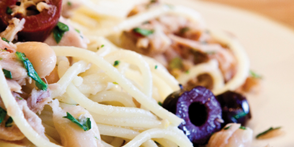 A white plate topped with pasta covered in sauce