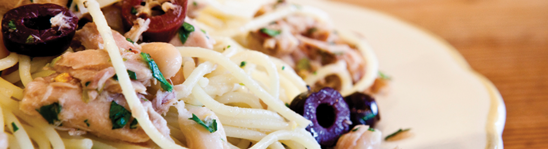 A white plate topped with pasta covered in sauce