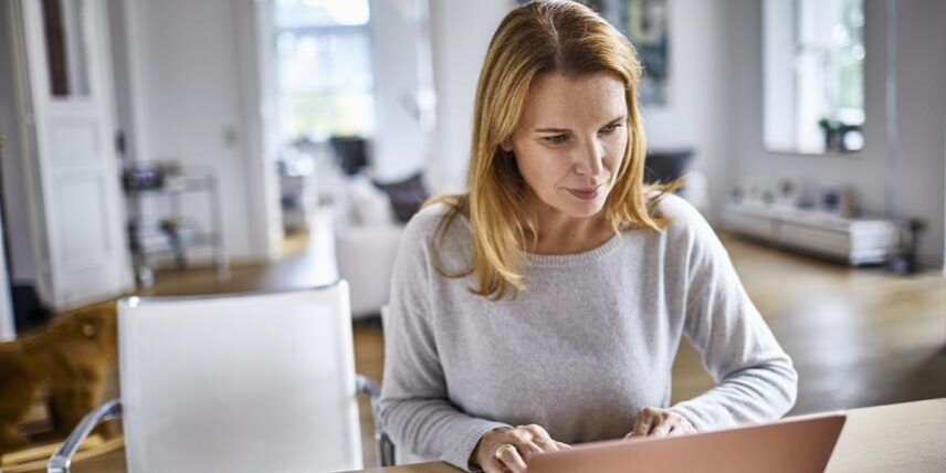 B4_GuideBrainHQ_1022301390_7 A woman sitting at a table using a laptop computer