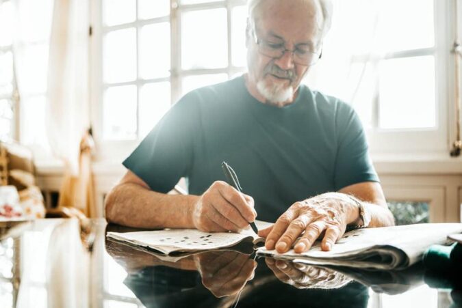 A man sitting at a table writing on a piece of paper