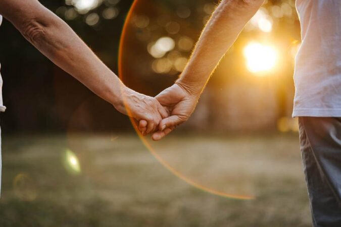 A close up of two people holding hands