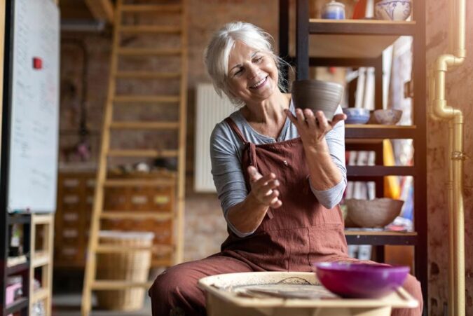 A woman sitting on a stool holding a cup