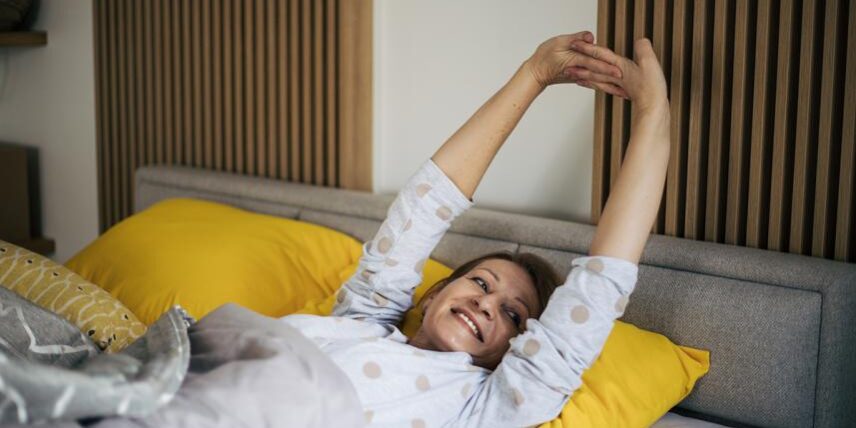 B4_BetterSleep_1394834380_9 A woman laying on a bed with her arms in the air