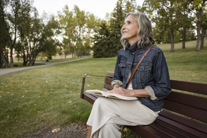 A woman sitting on a bench reading a book