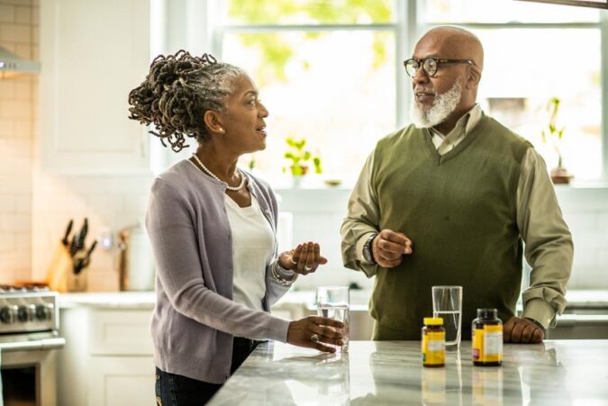 A man and a woman talking in a kitchen