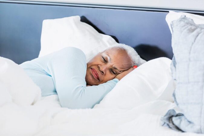 A woman laying in bed with her head on the pillow