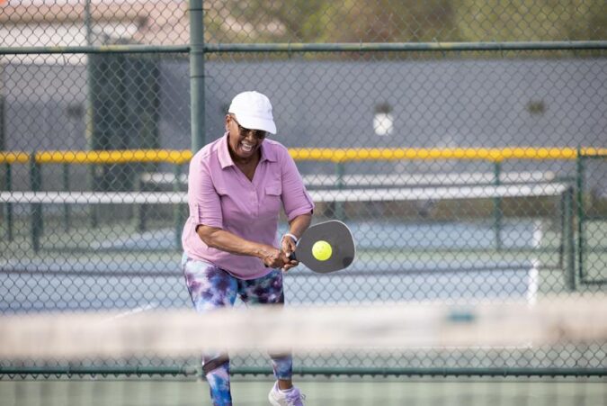 A man swinging a tennis racquet at a tennis ball