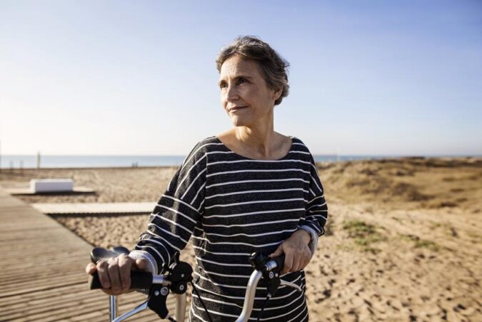 A woman riding a bike on a beach